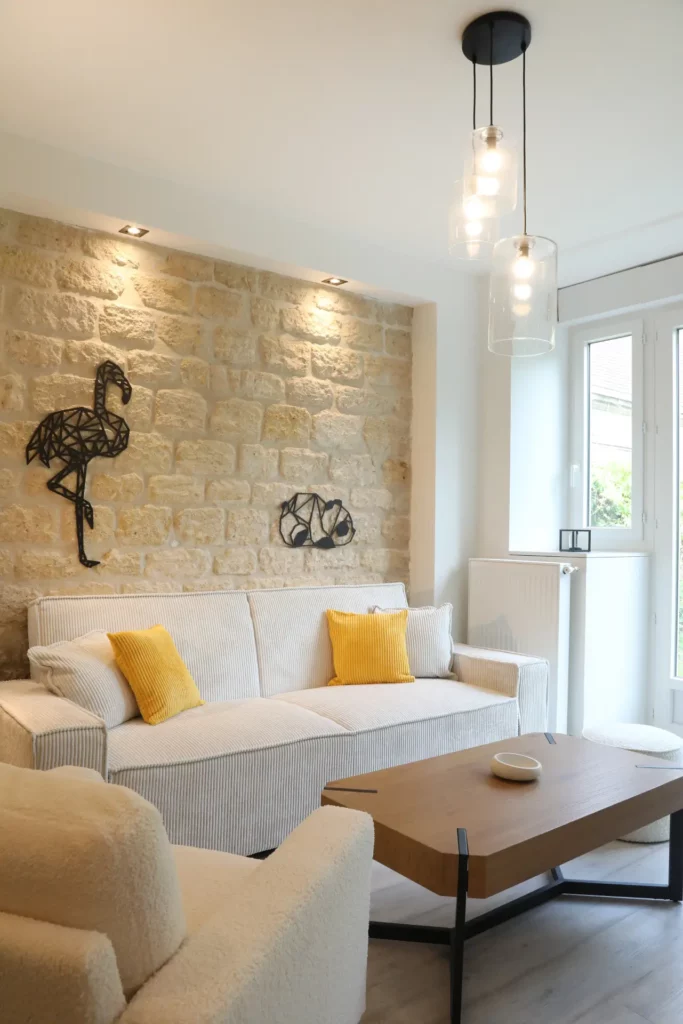 Décoration d'intérieur par Ilot Archi : espace détente avec canapé en velours côtelé clair et table basse en bois massif.