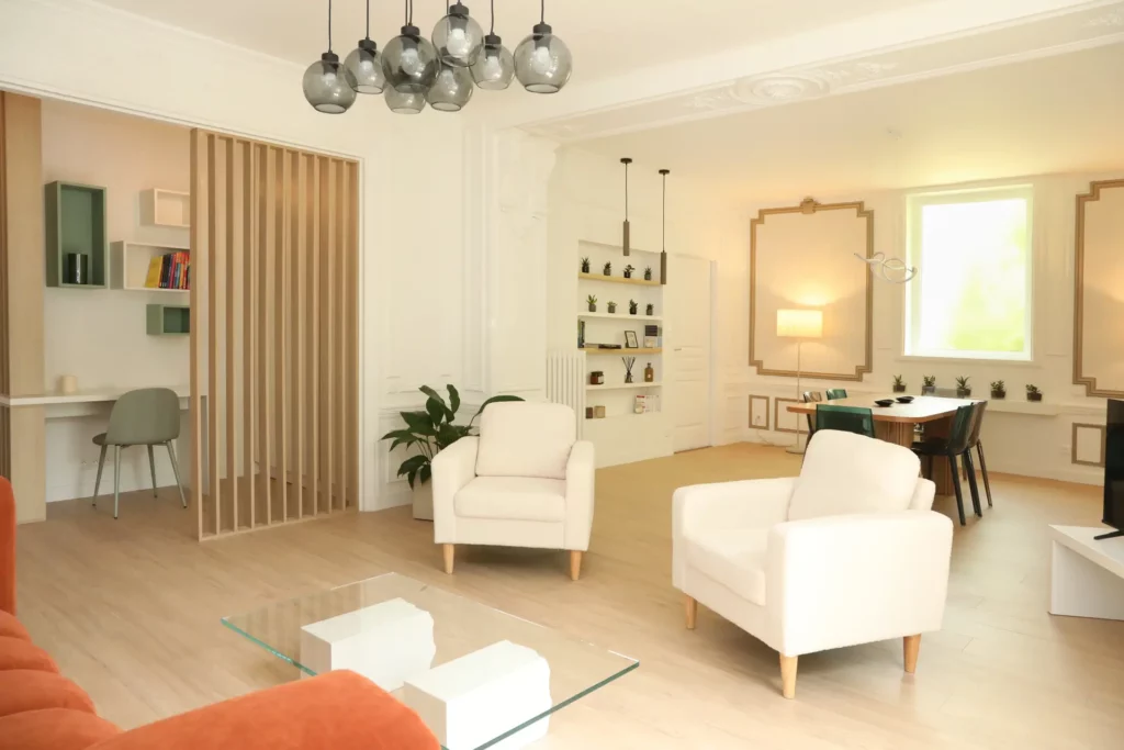Agencement d'un coin bureau séparé par un claustra en bois dans le salon d'un appartement T5 par Ilot Archi à Chantilly.