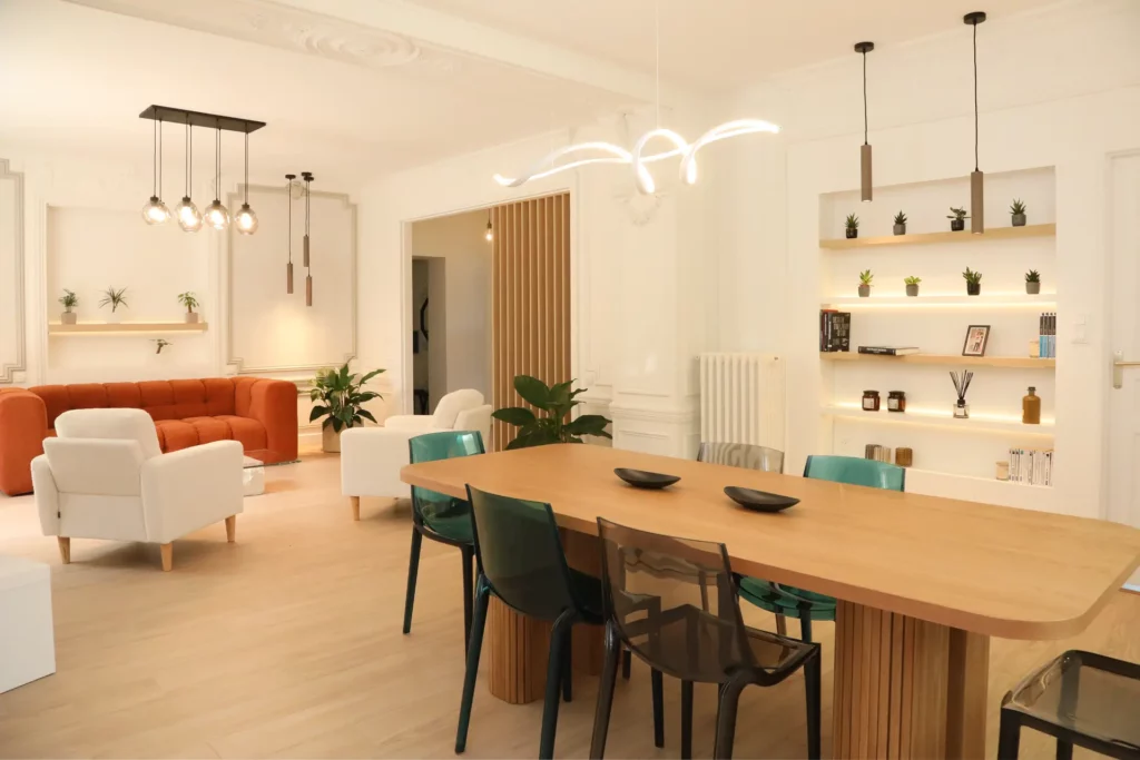 Vaste pièce de vie d'un T5 bourgeois à Chantilly aménagé par Ilot Archi avec parquet clair, table en bois massif et canapé terracotta.
