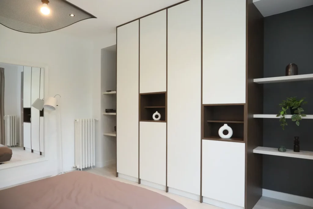 Agencement d'une suite parentale à Chantilly par Ilot Archi avec grand dressing sur mesure, miroir mural et parquet clair.